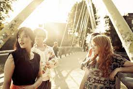 Młode dziewczyny stoją na moście i patrzą w dal.