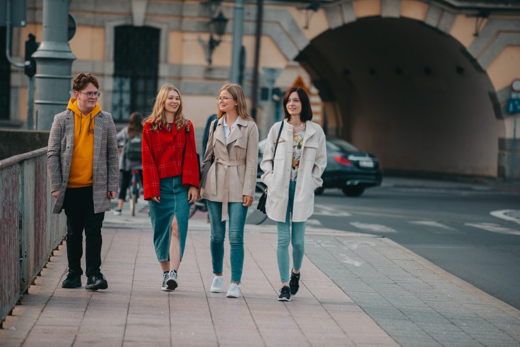 Czworo młodych ludzi idzie przez most uniwersytecki