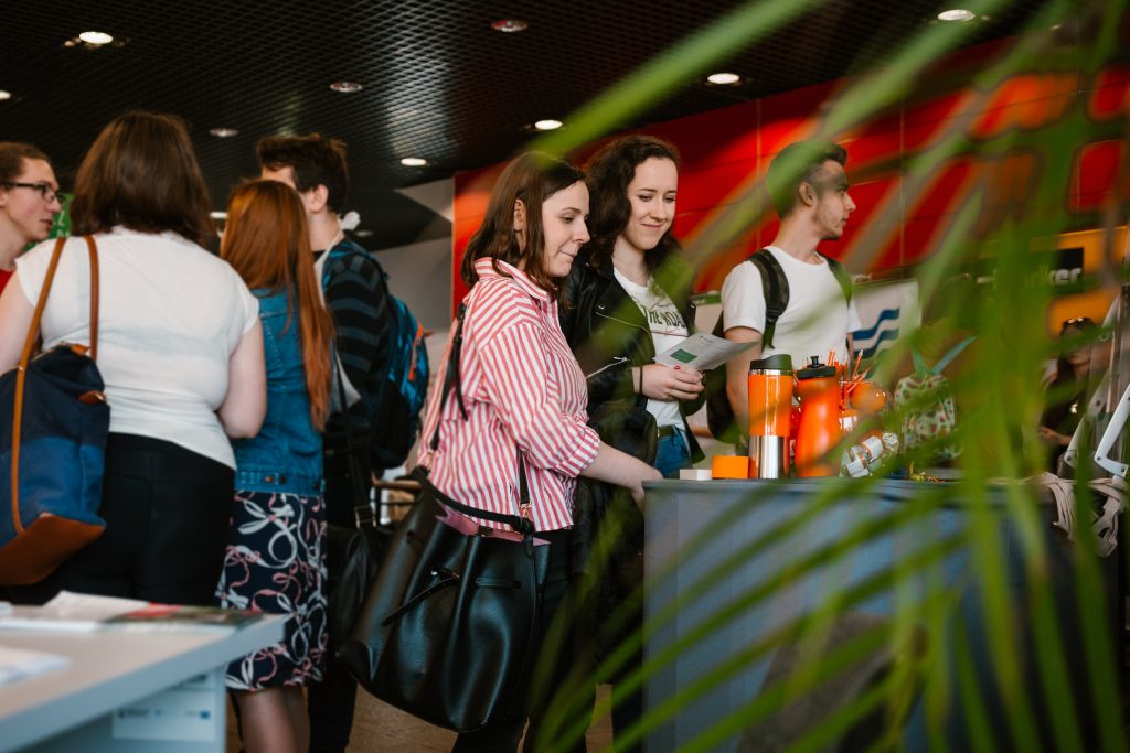 Studentki stojące przy stoisku pracodawcy podczas targów pracy