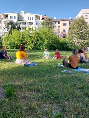 Grupa kobiet siedząca na kocach na łące