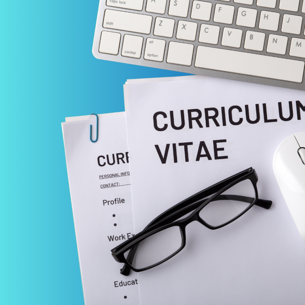 Grafika pokazujące kartki z napisem CV oraz kawałek klawiatury. Na kartkach leżą okulary w czarnej oprawce.