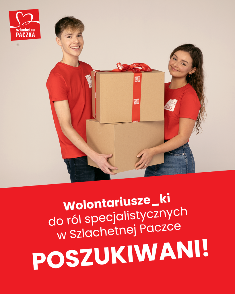 Dwoje młodych osób w czerwonych t-shirtach trzyma wspólnie dwa duże kartony, z czego ten na wierzchu ma kokardę z napisem Szlachetna Paczka